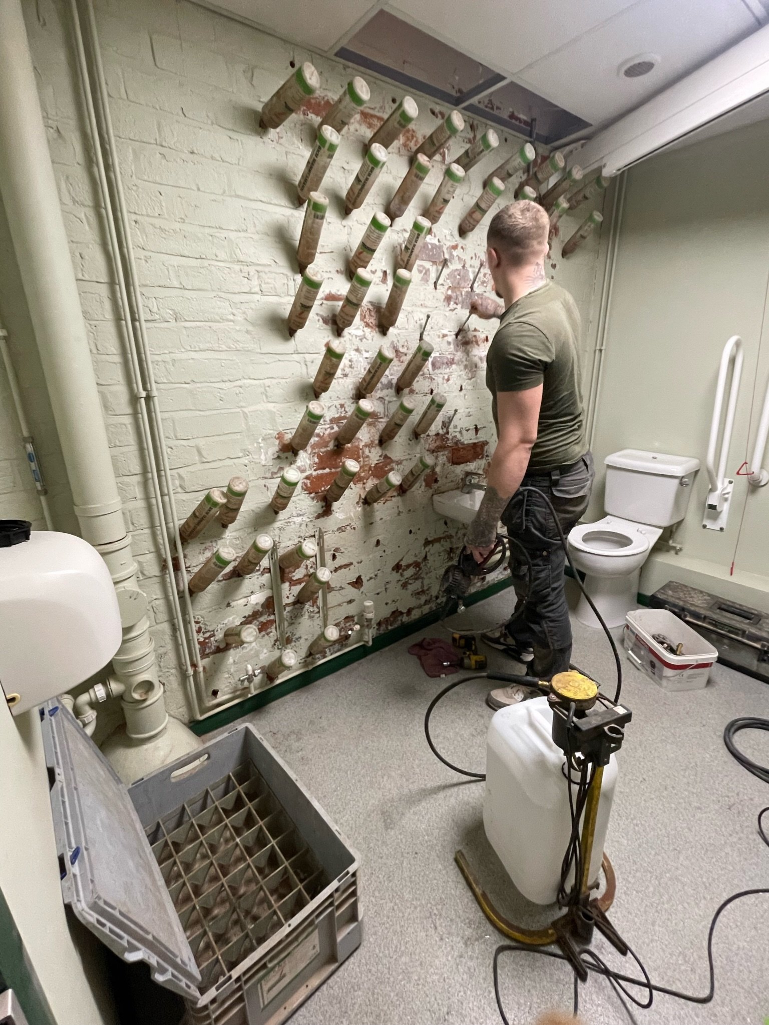 Man doing Damp proofing in bathroom , using the BKM HZ 250 | damp proof specialist Midlands