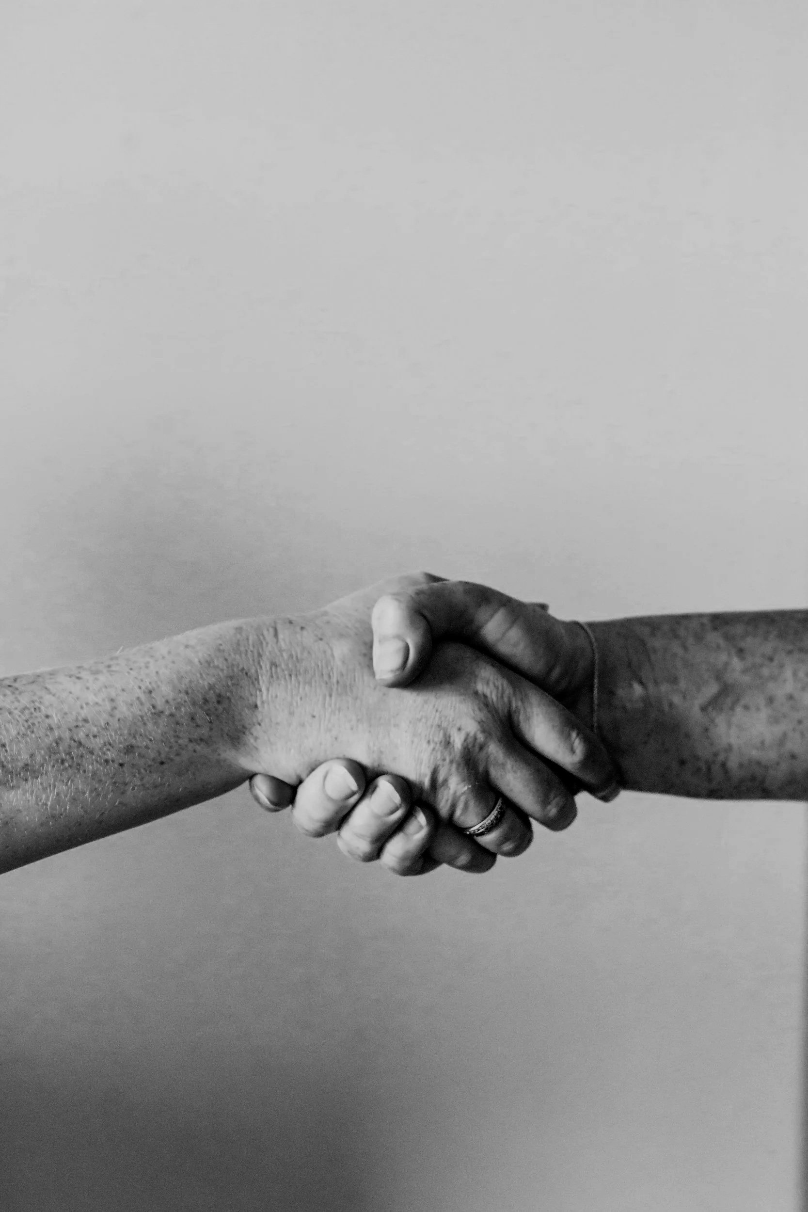 A black and white photo of two hands shaking.