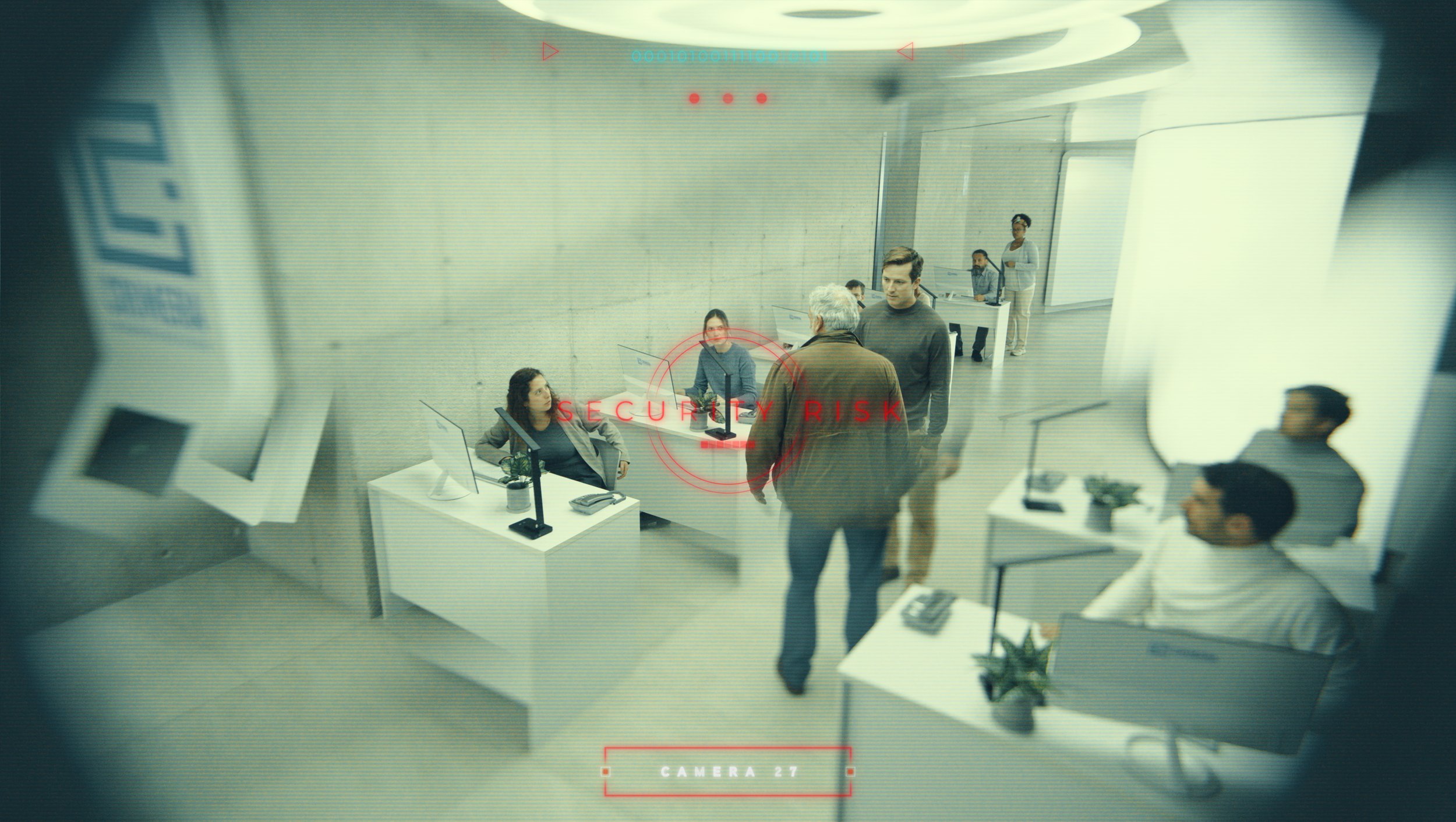 Security camera view of a modern office reception area with several employees and visitors, with a red overlay displaying 'SECURITY RISK' and camera information at the bottom.