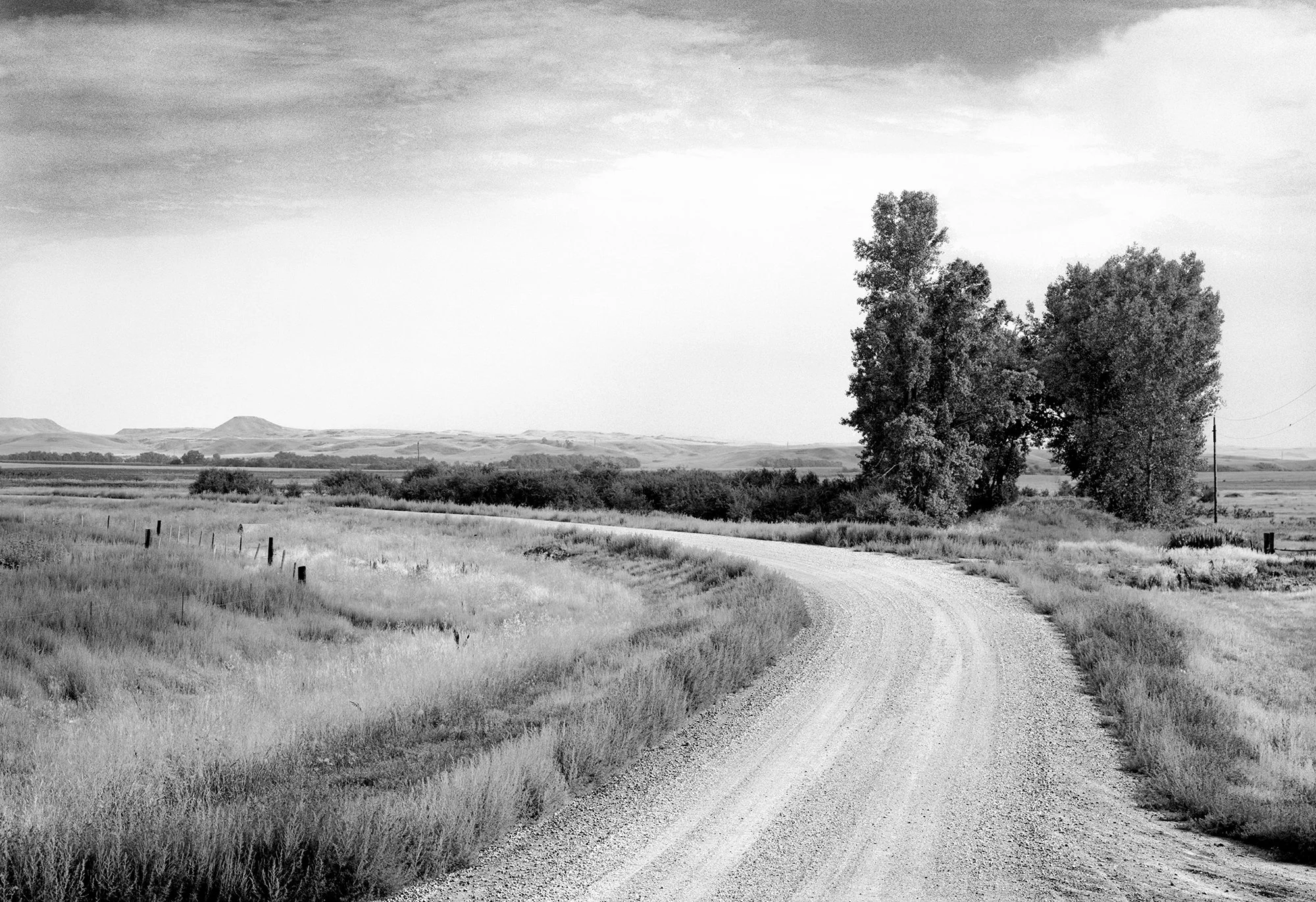  
 
 County Road 
 Price, North Dakota 1987 
 I had a big old twelve-passenger van that I was driving. I put the tripod up on the roof to get the camera high enough. The camera was steady, but I wasn’t. I was trying to catch what it means to move thr
