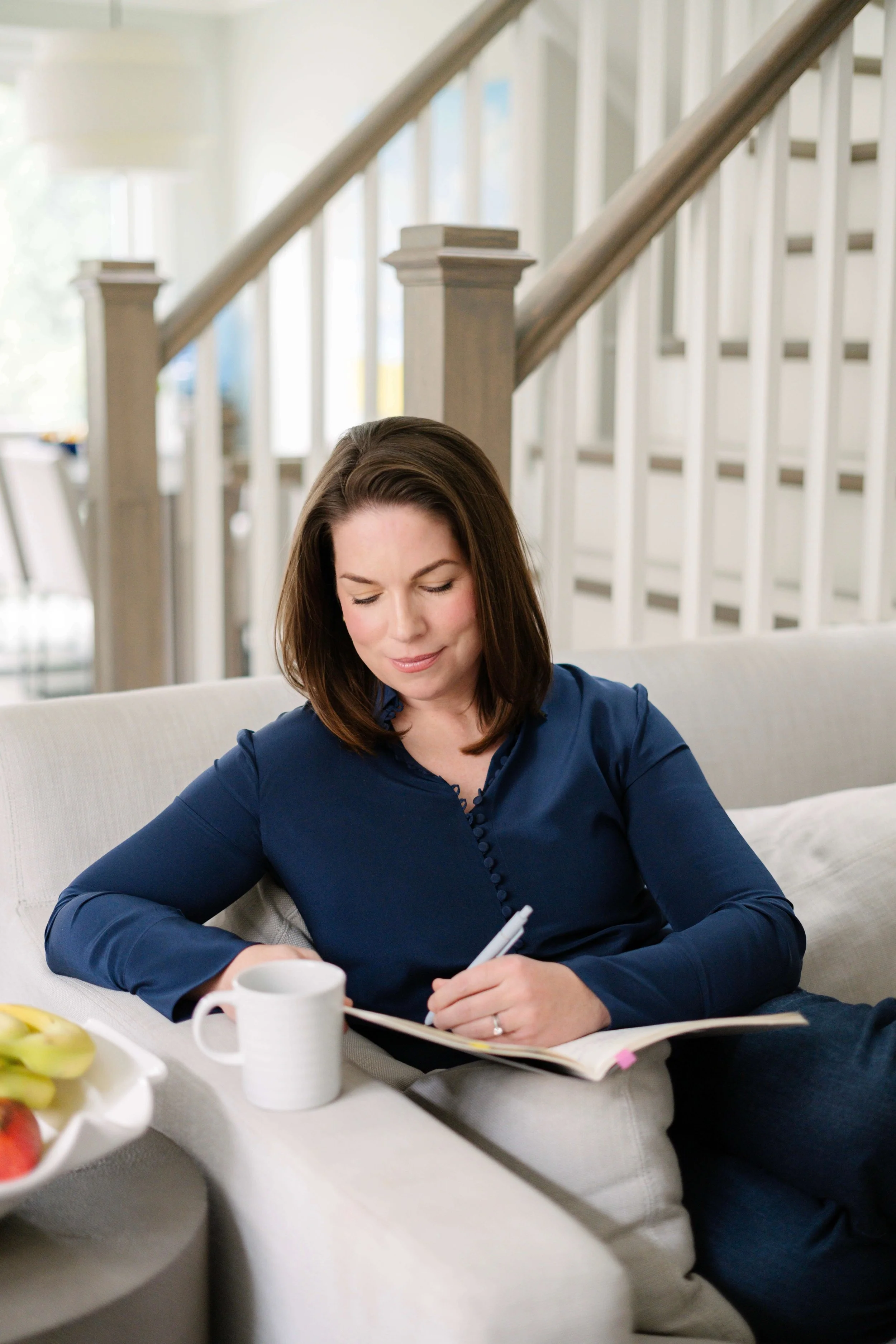 Courtney Edmundson sitting on her sofa taking notes.