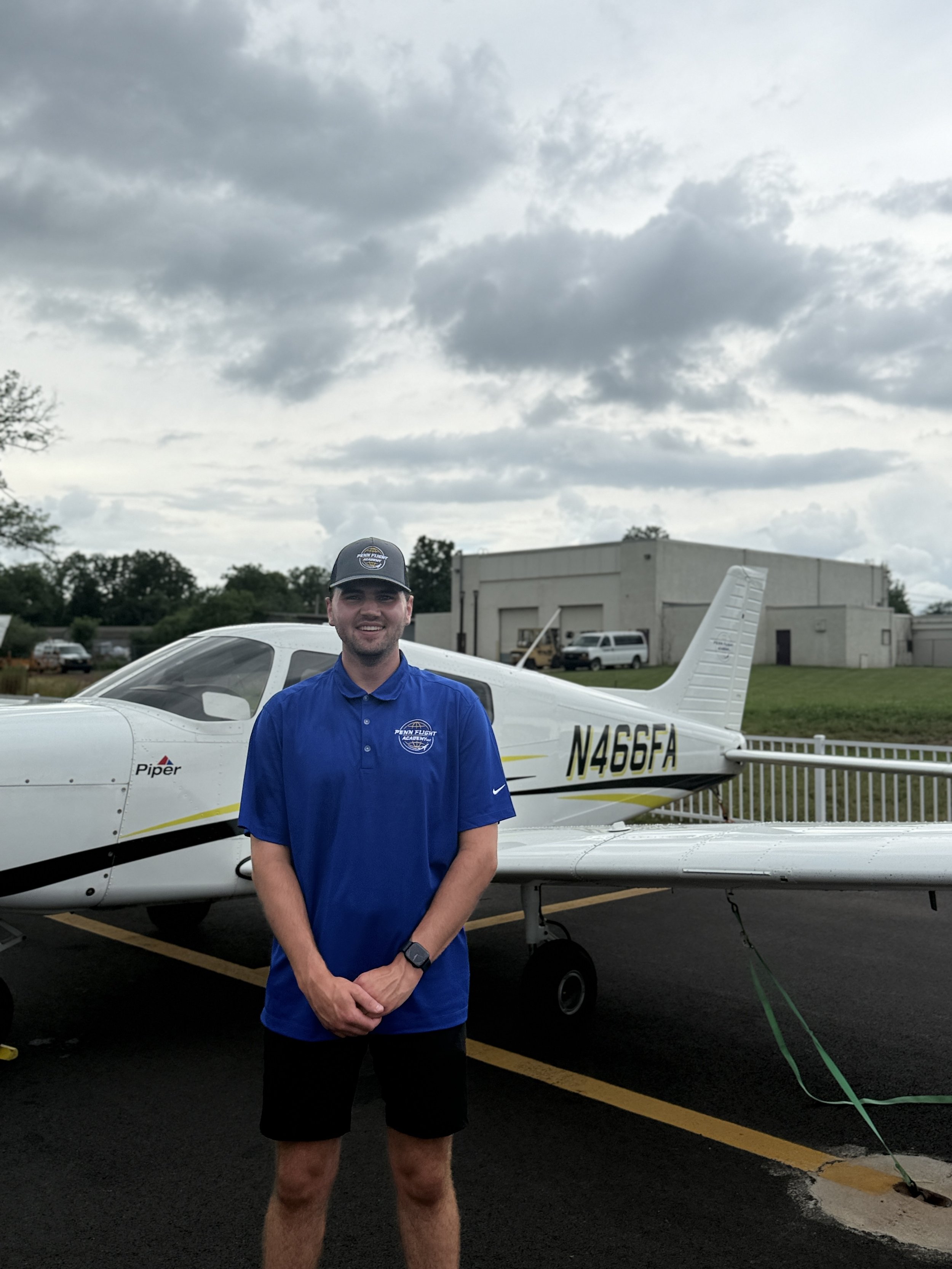 Smiling person wearing Kent State jacket with a blurred logo in the background.