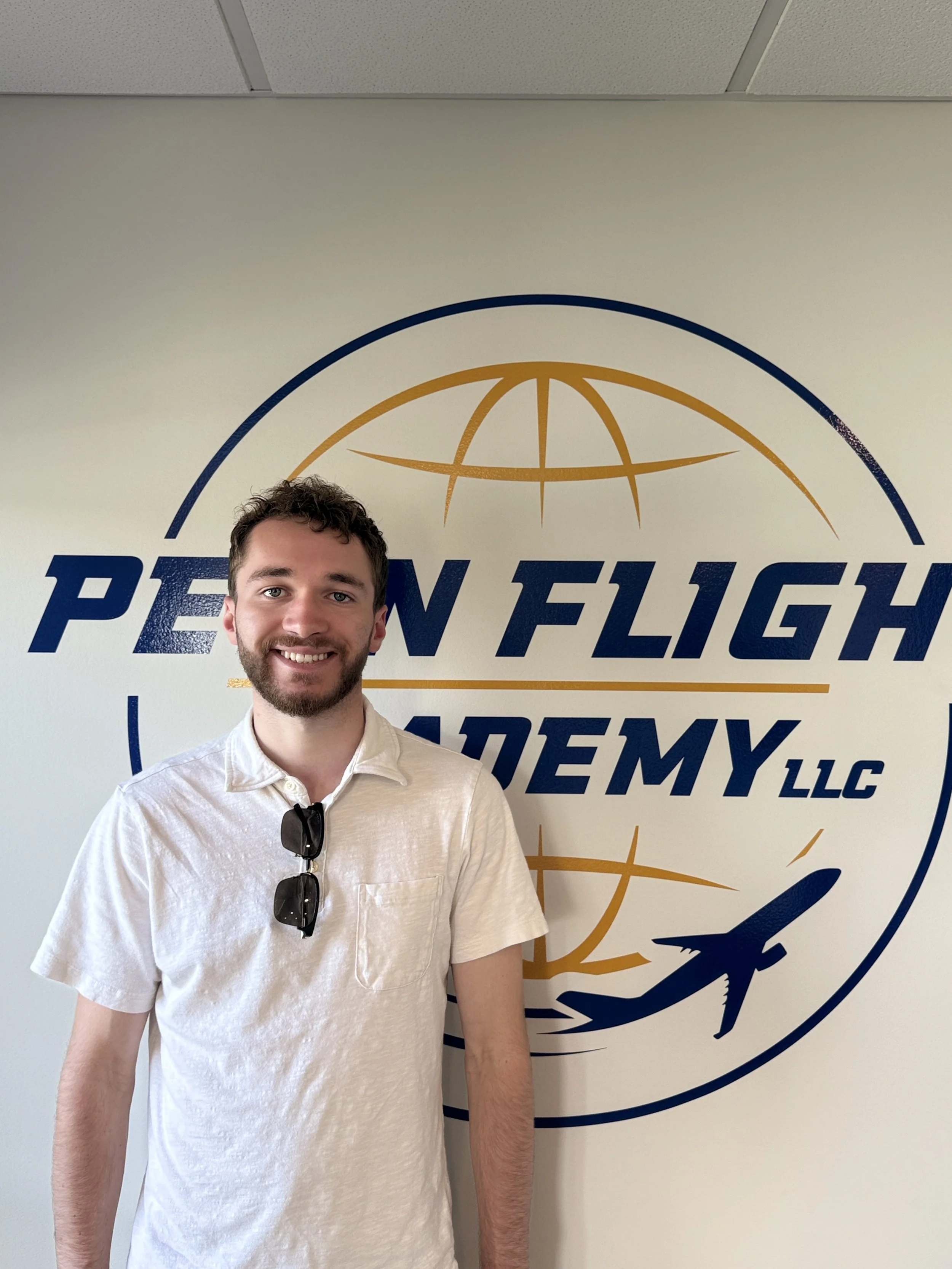 Penn Flight Academy LLC logo featuring a globe and airplane graphic.