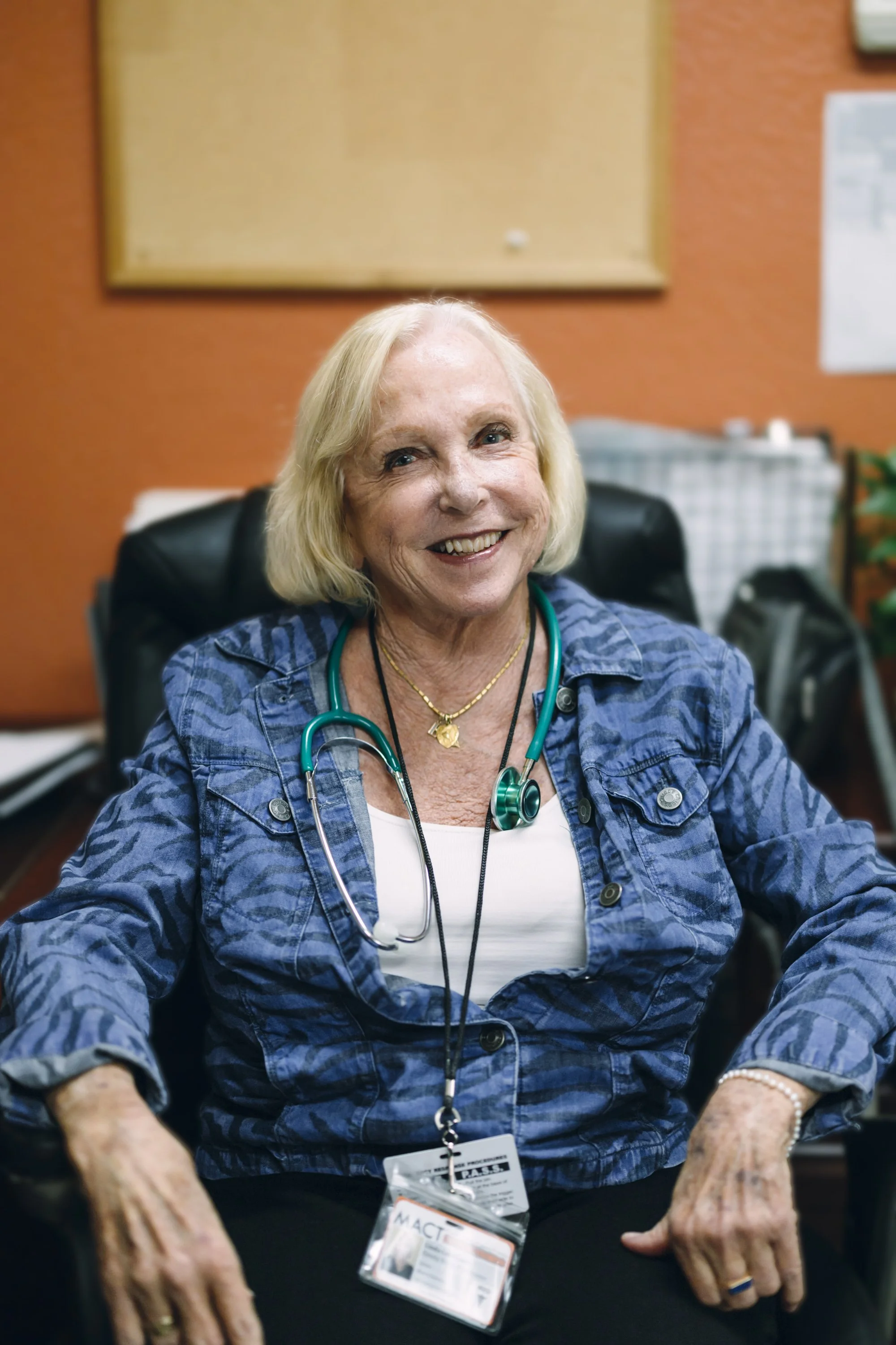 A smiling woman medical provider standing in a medical clinic exam room