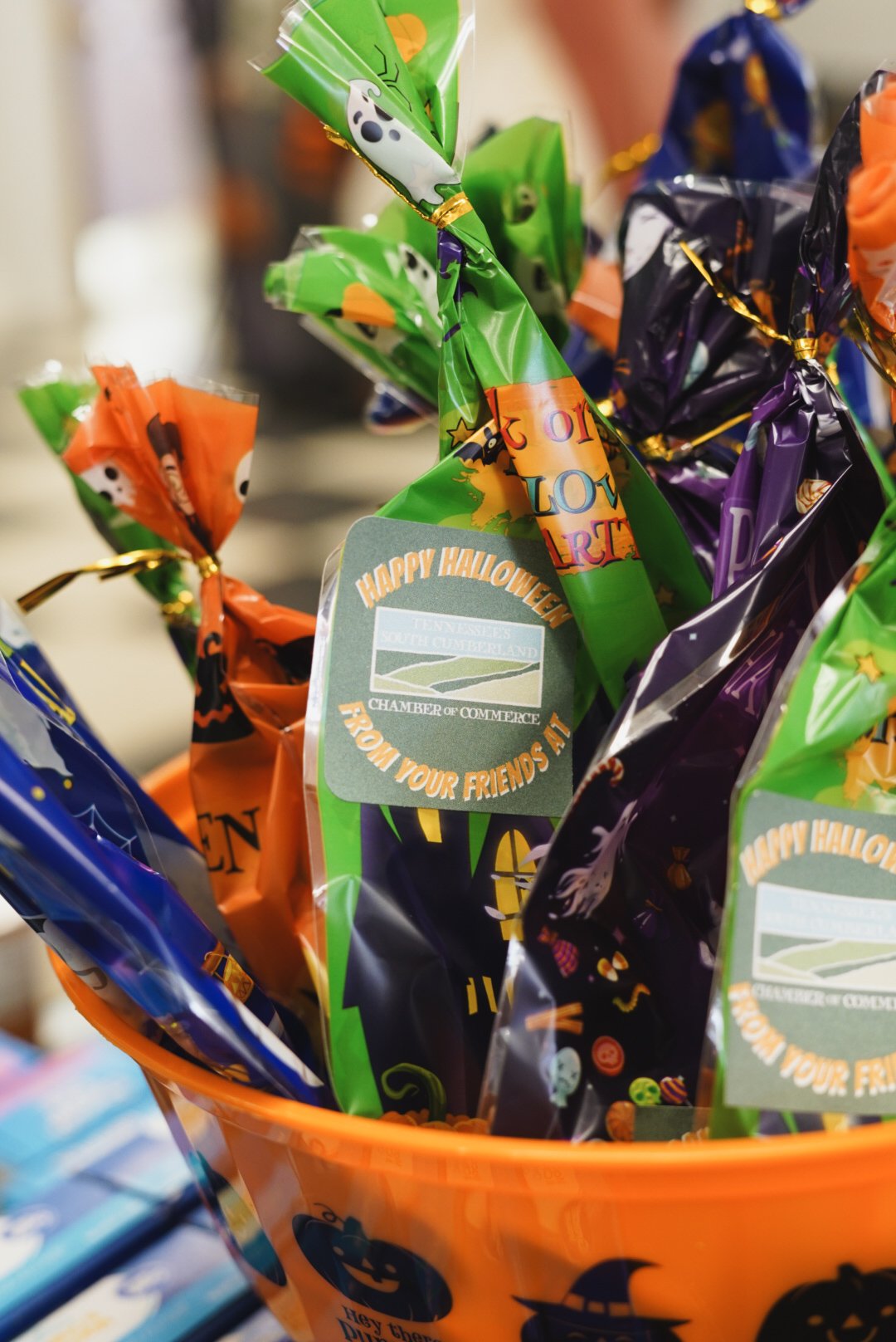Halloween-themed candy bags in an orange pumpkin-shaped container with a 