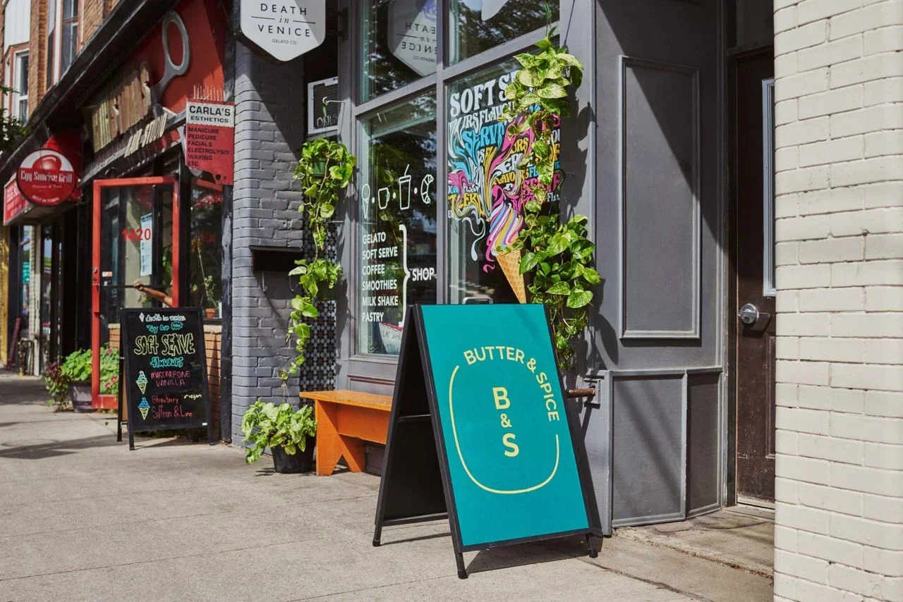 Storefront entrance of Butter and Spice bakeshop and Death in Venice Gelato on Dundas Street West in Toronto