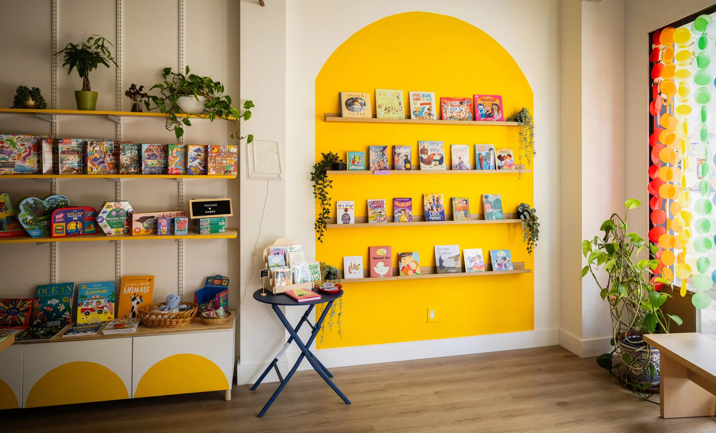 Yellow archway wall displaying children's books inside Nuts and Shells bookshop on Dundas Street West in Toronto