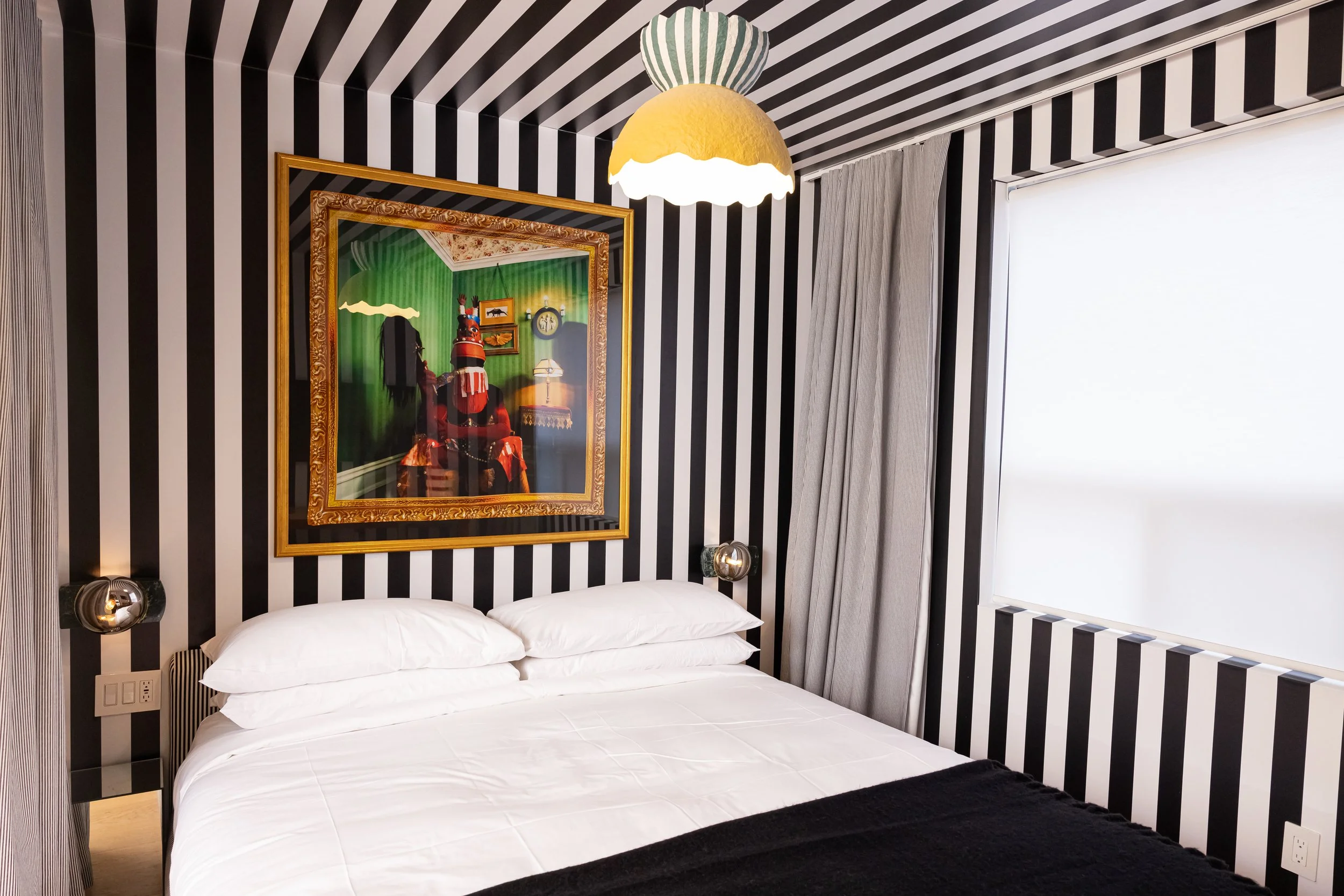 Boutique guest room with striped wall decor and local art at Ode Toronto hotel on Dundas Street West