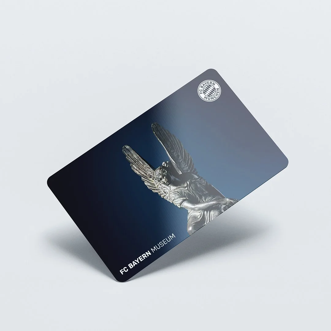 Eine Karte des FC Bayern Museums mit einem weißen Engel mit Flügeln auf dunklem blauen Hintergrund
