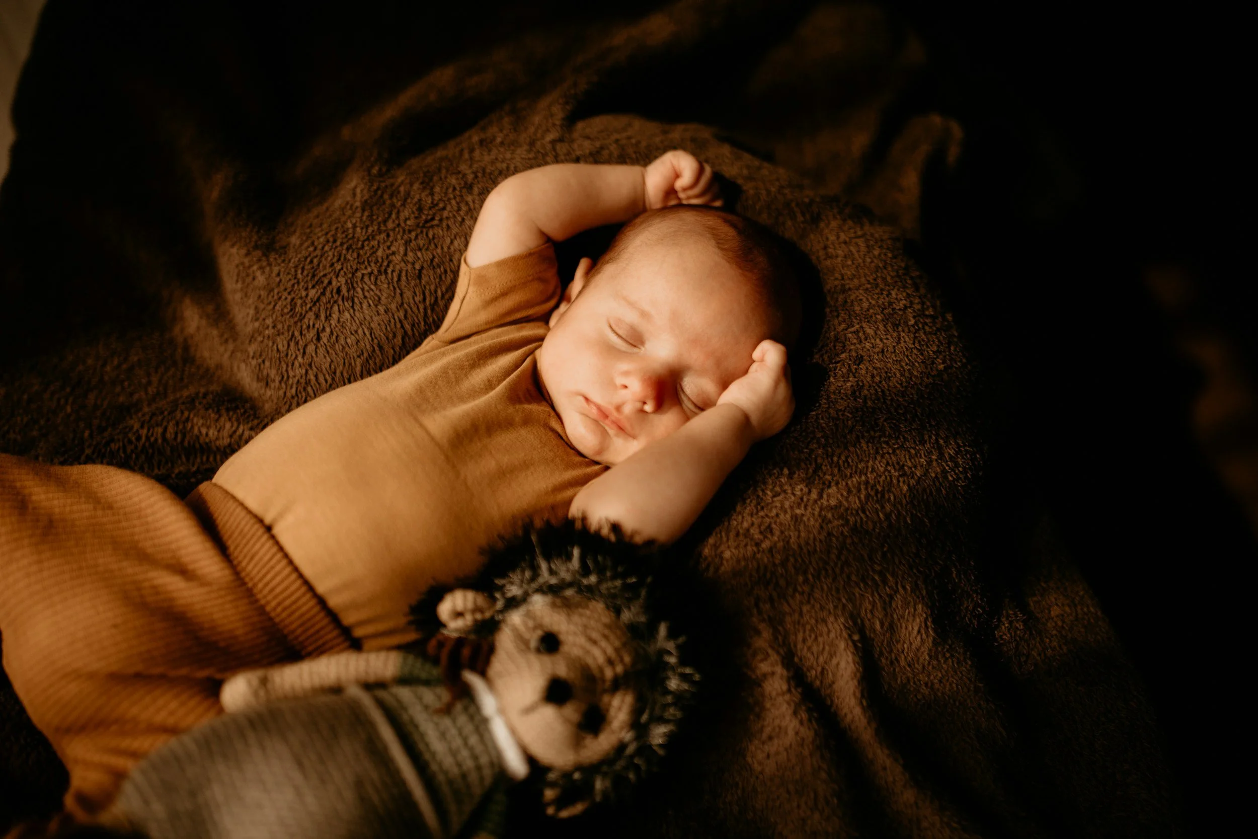 Slapende baby met een knuffeltje naast zich