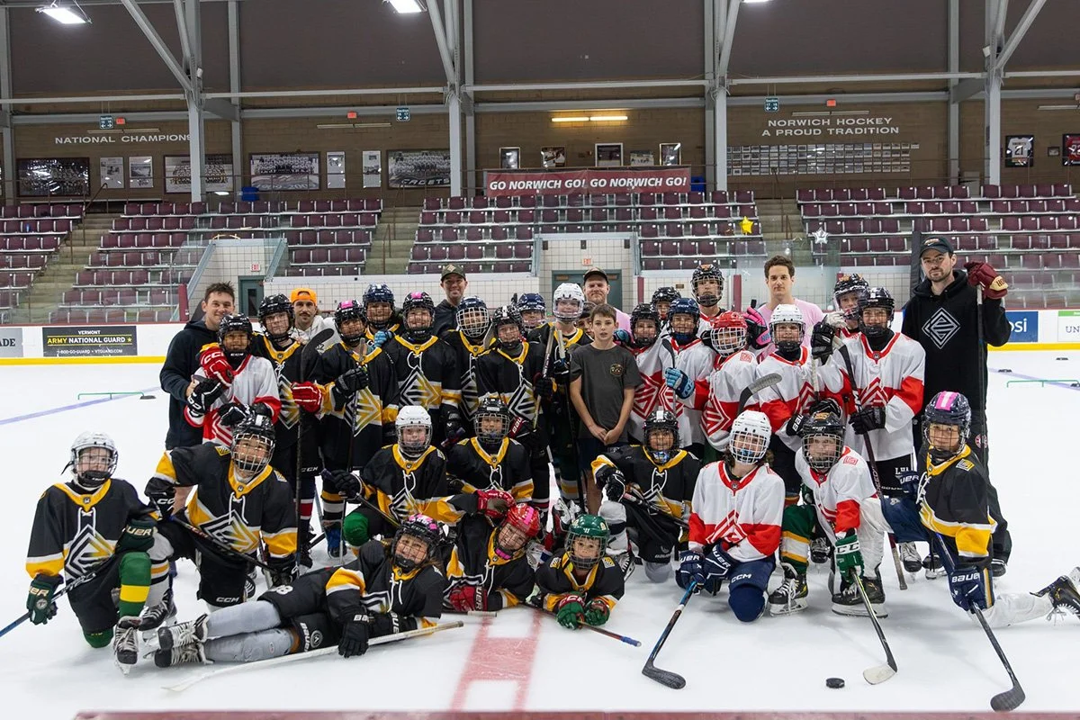Group of ELEV802 DENVER youth hockey player at indoor hockey rink with their coaches.