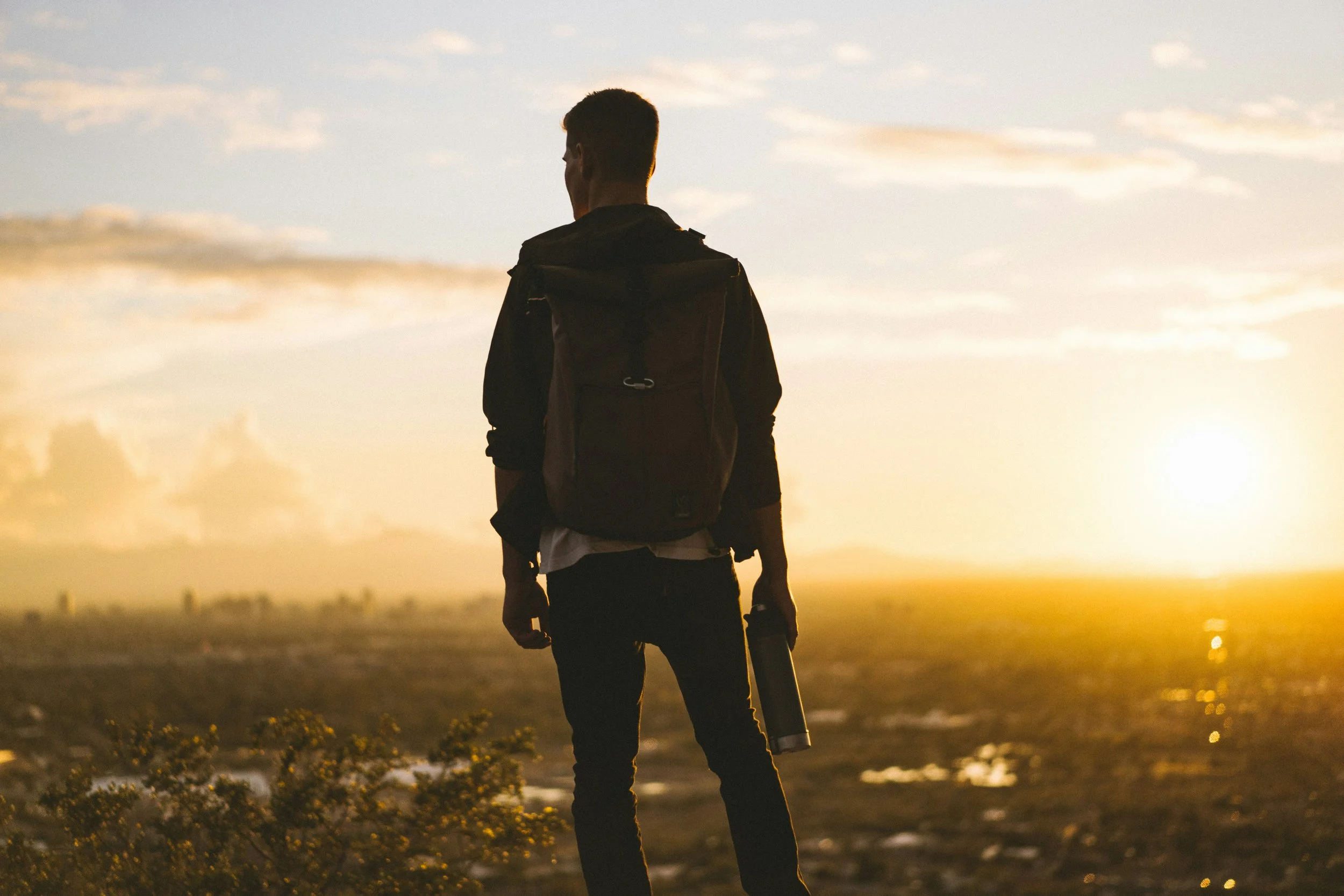 man-on-hilltop-watching-sunset