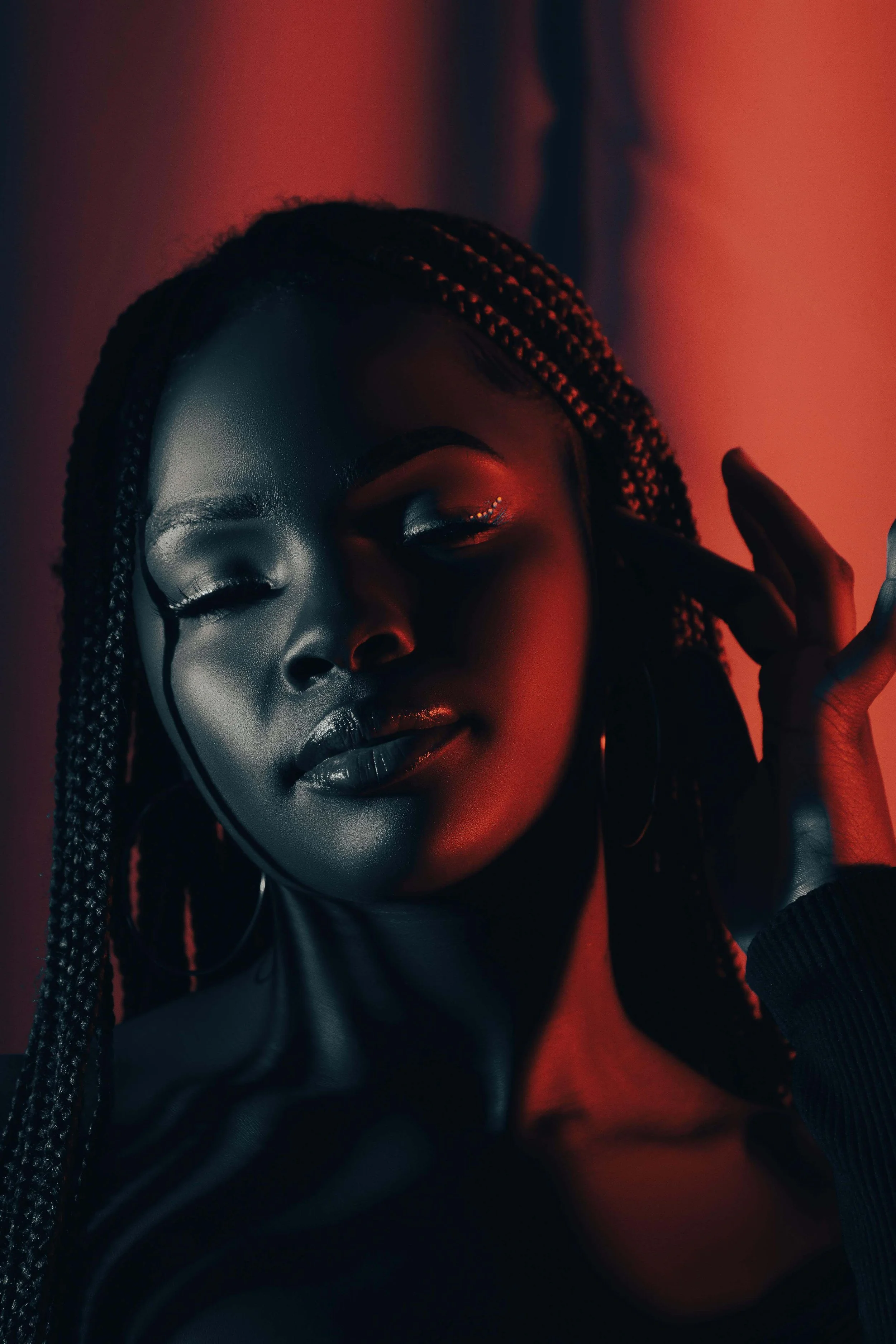 A young woman closes her eyes, bathed in deep red light. Do you feel dysregulated without knowing why? Emotional regulation therapy in Davie, FL, offers a supportive space to explore your emotions and develop tools to feel more grounded.
