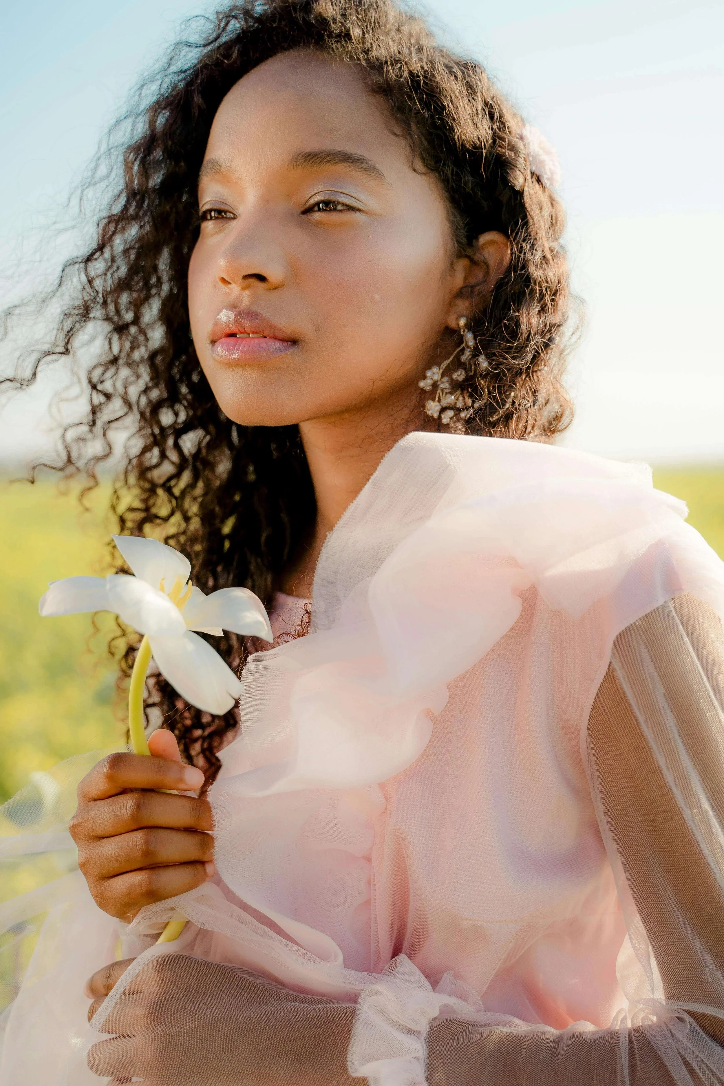 A woman in a soft pink dress holds a white flower. What would your mental health look like if you finally released the patterns holding your relationships back? A relationship therapist in Davie, FL can guide you toward meaningful connection.