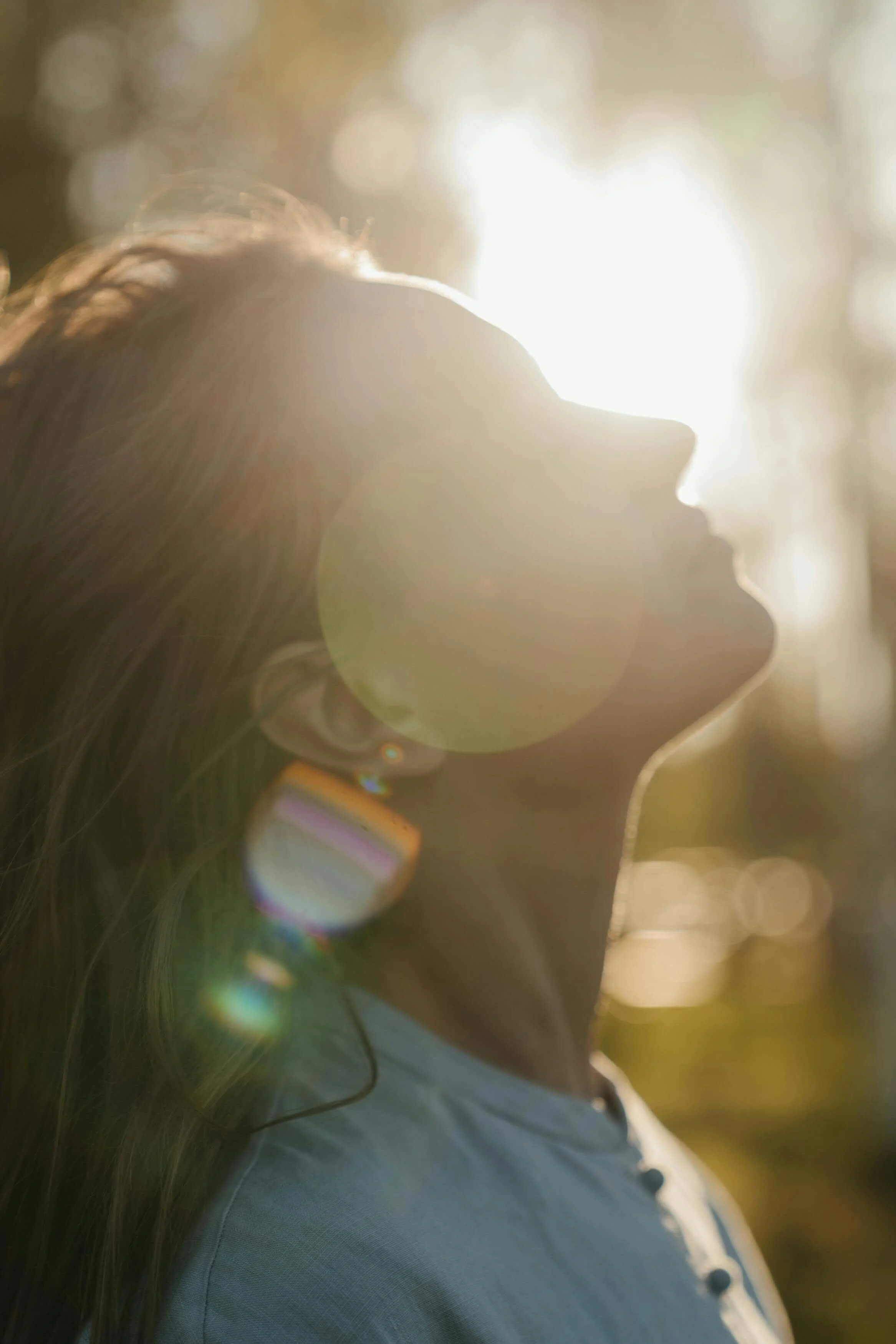A woman tilts her face upward into golden sunlight. Are your emotional triggers making it hard to feel calm and safe? Emotional regulation therapy in Davie, FL, can help you understand what drives your reactions and find your way back to stillness.