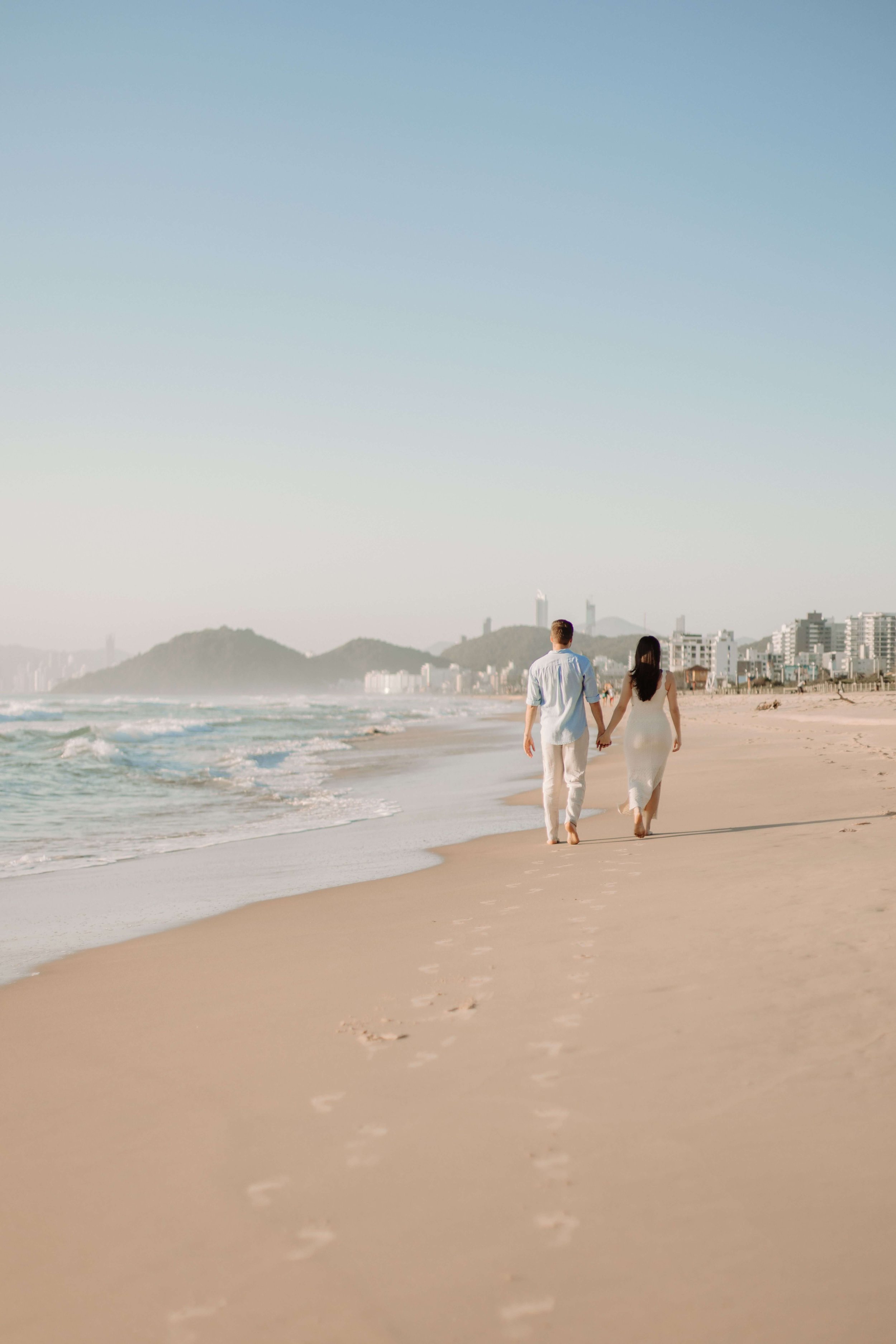 A couple walks hand in hand along a quiet beach at sunset. Does fear of missing out distract you from meaningful moments happening in your life? An emotional regulation therapist in Davie, FL, supports healthier emotional awareness.