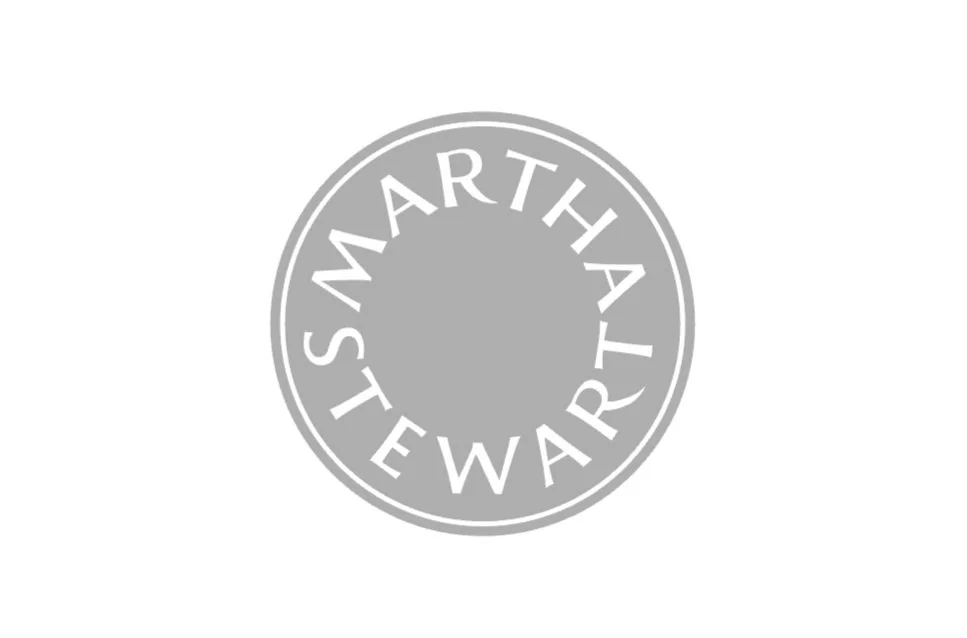 Gray circular logo with the words 'Martha Stewart' written along the inside of the circle.