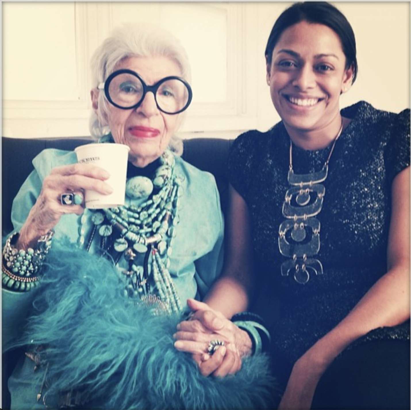 Madhu Puri and Iris Apfel holding hands on set during an interview about the Iris Apfel One Kings Lane estate sale.