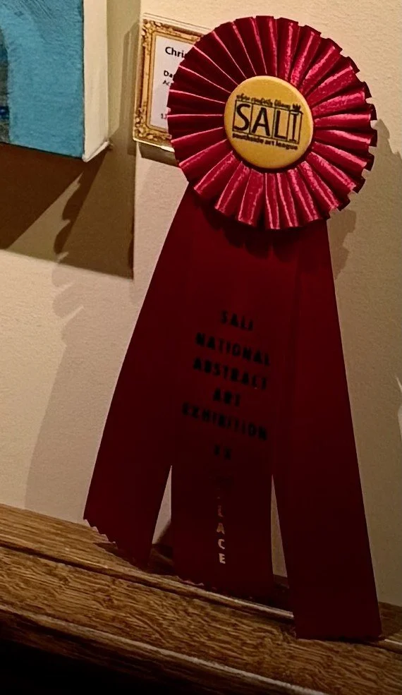 Red ribbon award with a yellow center that says "SALI" and black text reading "SALI National District Art Collection".
