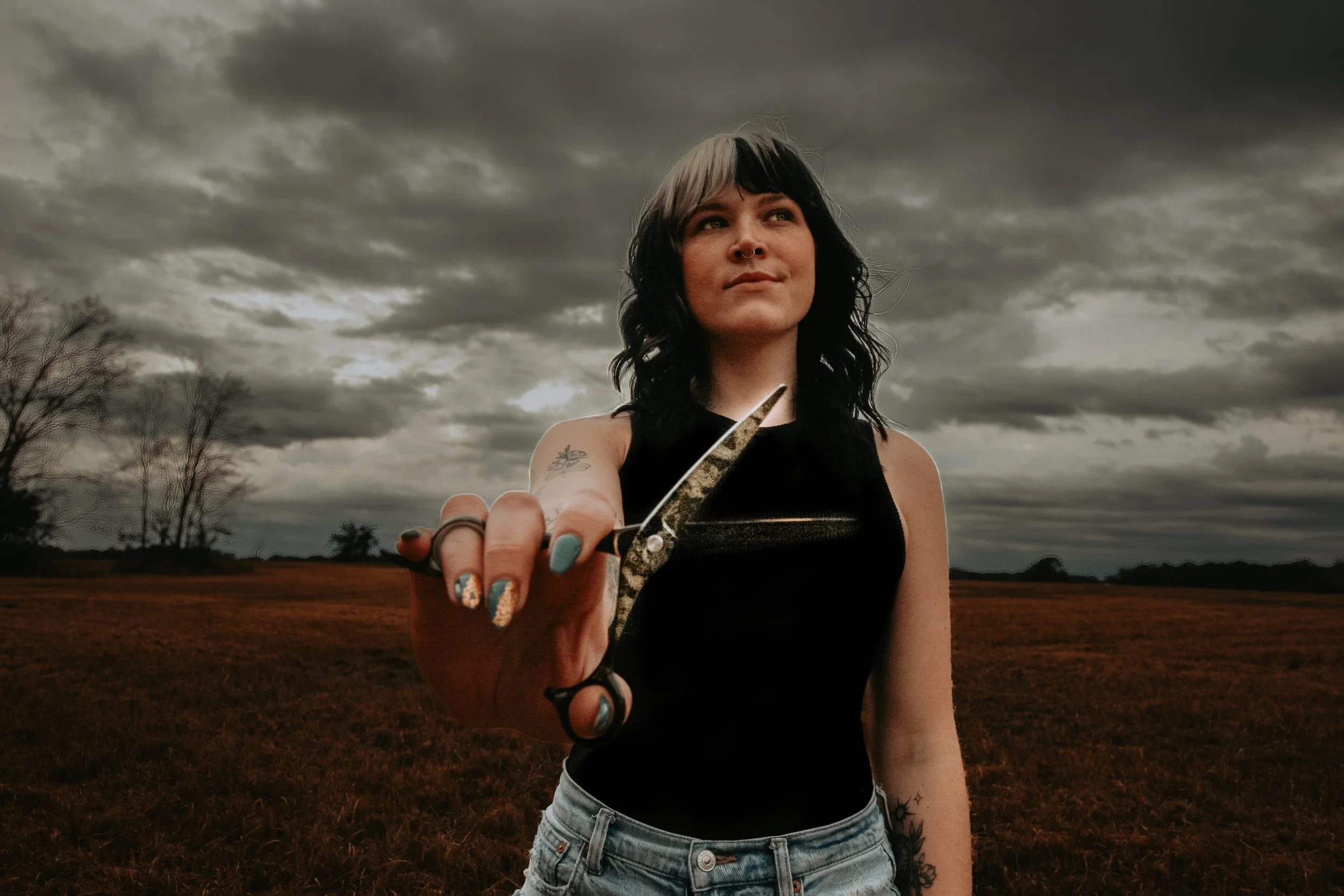 Woman holding scissors, stormy background.