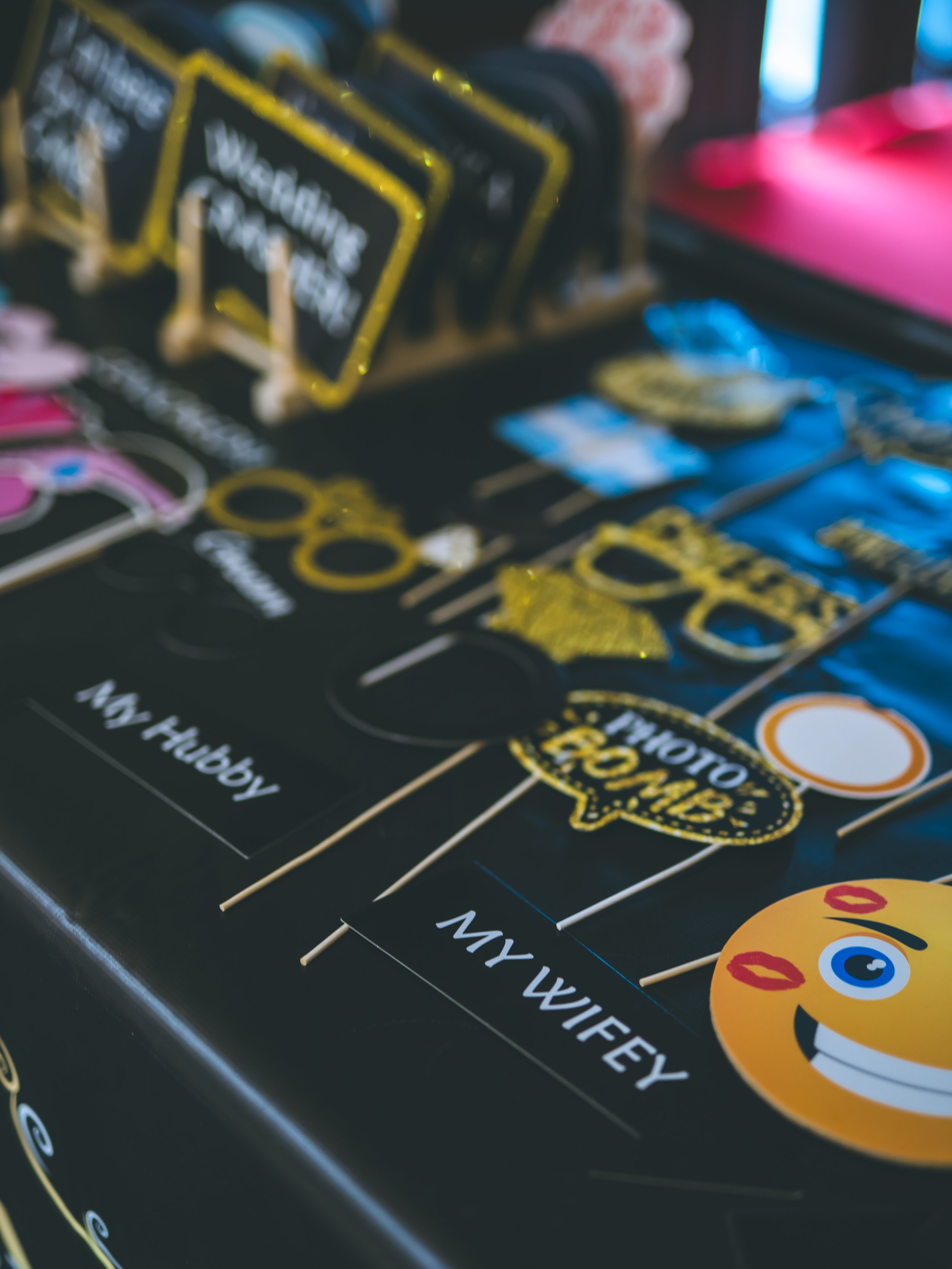 Close-up of decorative signs and stickers on a black surface, including phrases like "Way Heuristic" and images such as a smiling face with red lips and blue eyes.