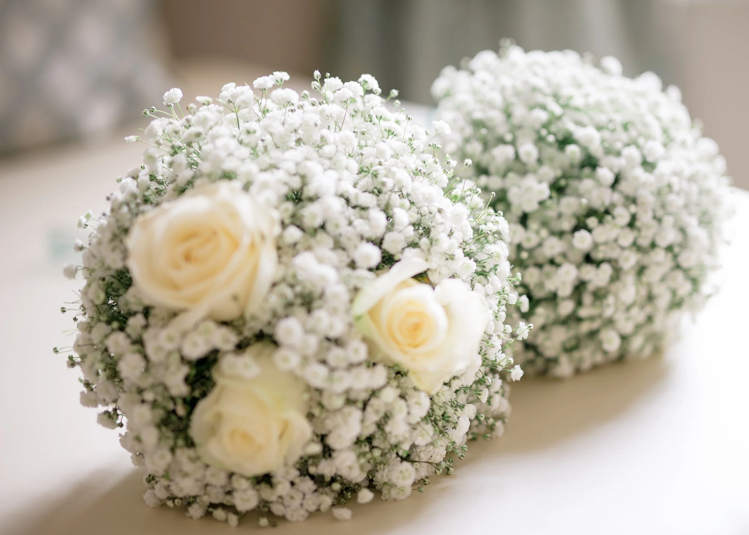A bouquet of white roses and baby's breath flowers.