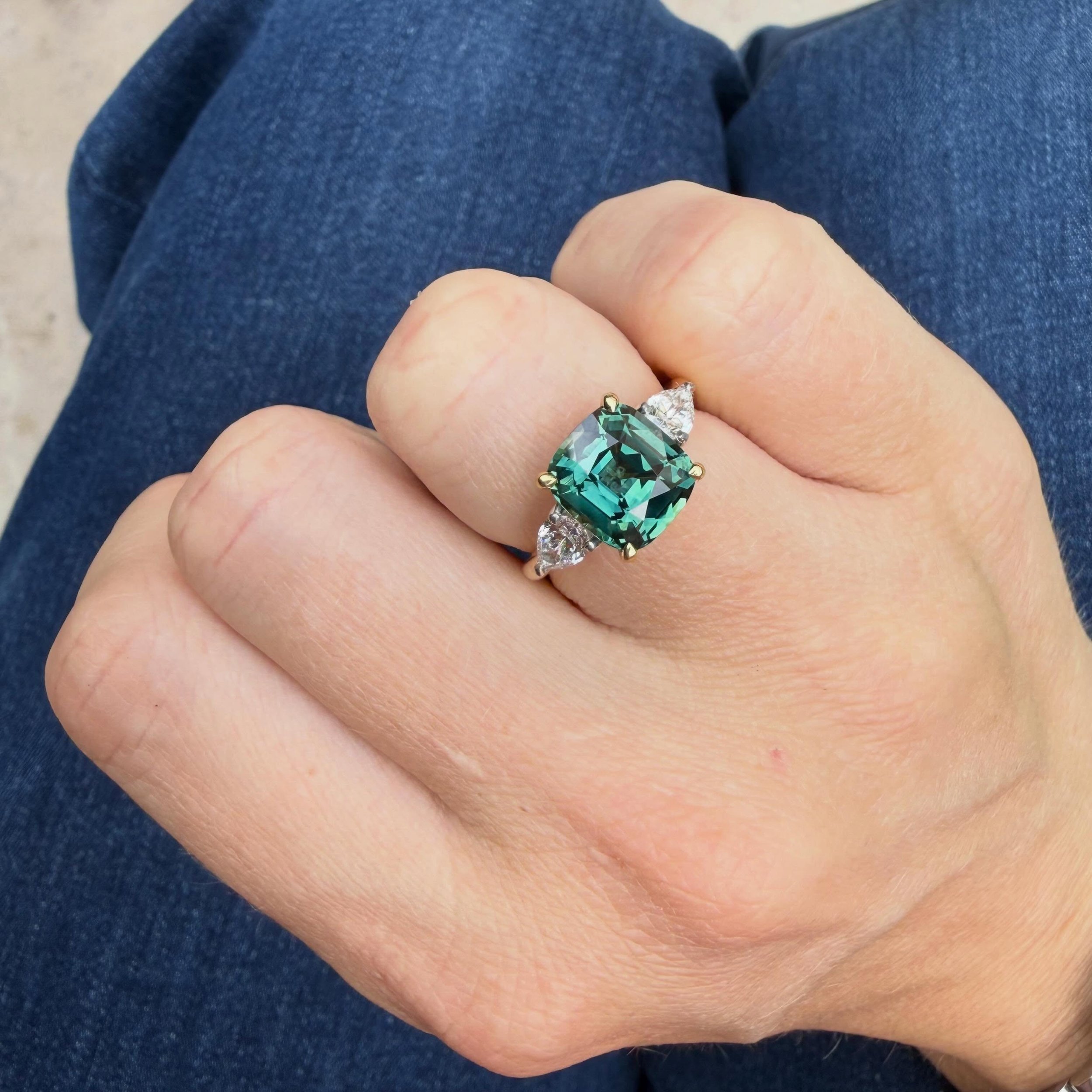 Colour of dreams! 💚 Cushion-cut teal sapphire &amp; pear-cut diamond three-stone ring. Mounted in 18ct yellow and white gold. 💍