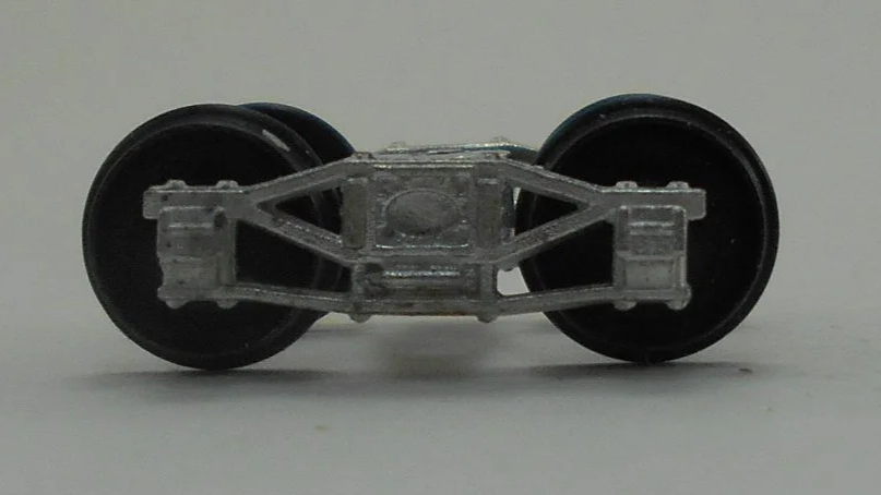 Close-up of a model train wheel assembly showing metal wheels and undercarriage details.