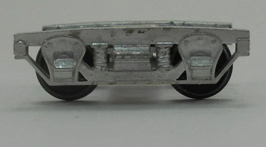 Close-up of a model train wheel assembly showing metal wheels and undercarriage details.