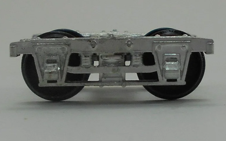 Close-up of a model train wheel assembly showing metal wheels and undercarriage details.