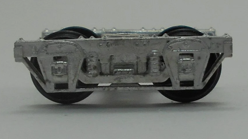 Close-up of a model train wheel assembly showing metal wheels and undercarriage details.