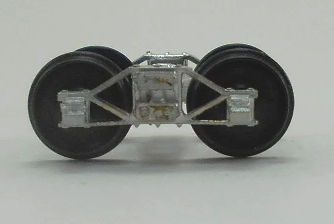 Close-up of a model train wheel assembly showing metal wheels and undercarriage details.
