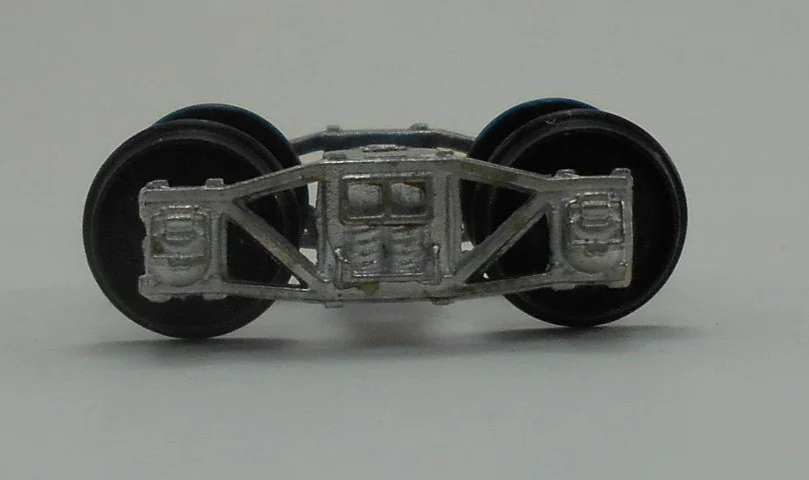 Close-up of a model train wheel assembly showing metal wheels and undercarriage details.