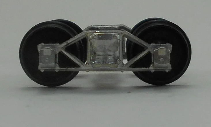 Close-up of a model train wheel assembly showing metal wheels and undercarriage details.