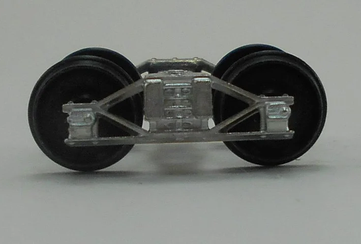 Close-up of a model train wheel assembly showing metal wheels and undercarriage details.