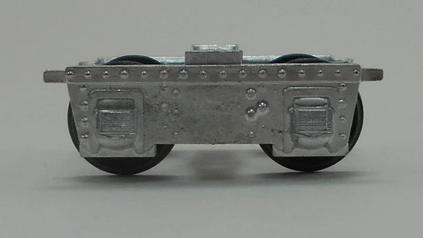 Close-up of a model train wheel assembly showing metal wheels and undercarriage details.