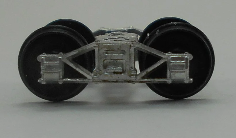 Close-up of a model train wheel assembly showing metal wheels and undercarriage details.