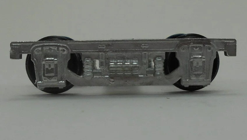 Close-up of a model train wheel assembly showing metal wheels and undercarriage details.