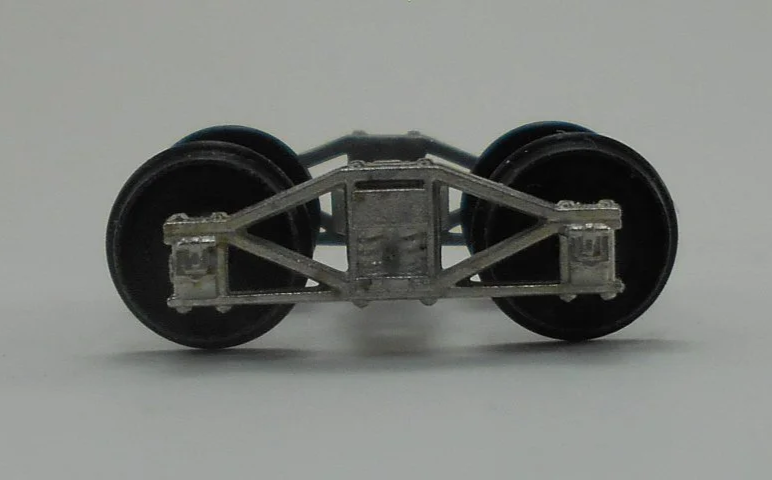 Close-up of a model train wheel assembly showing metal wheels and undercarriage details.