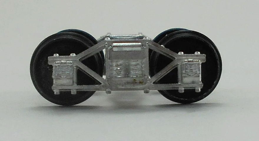 Close-up of a model train wheel assembly showing metal wheels and undercarriage details.