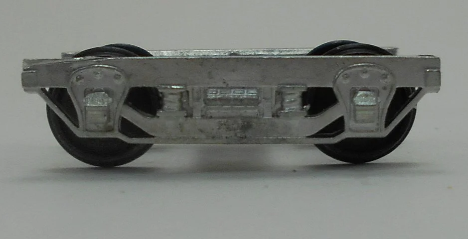Close-up of a model train wheel assembly showing metal wheels and undercarriage details.