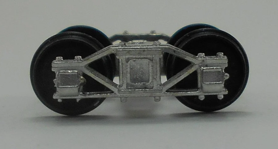Close-up of a model train wheel assembly showing metal wheels and undercarriage details.