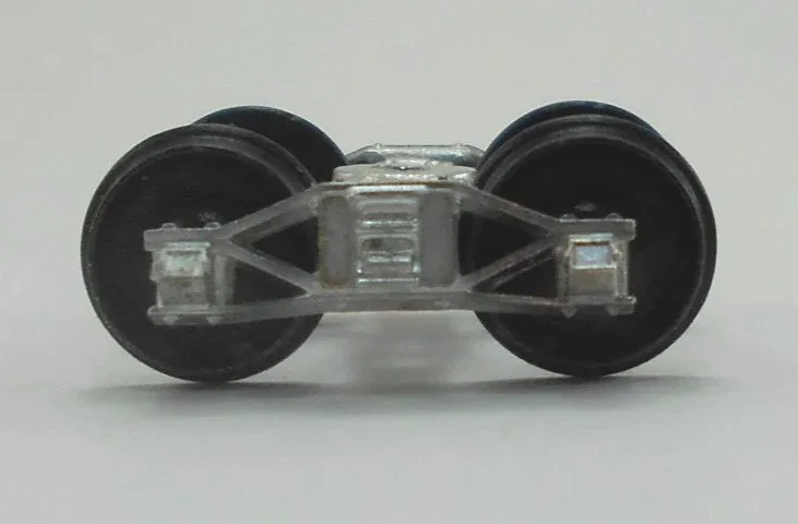 Close-up of a model train wheel assembly showing metal wheels and undercarriage details.