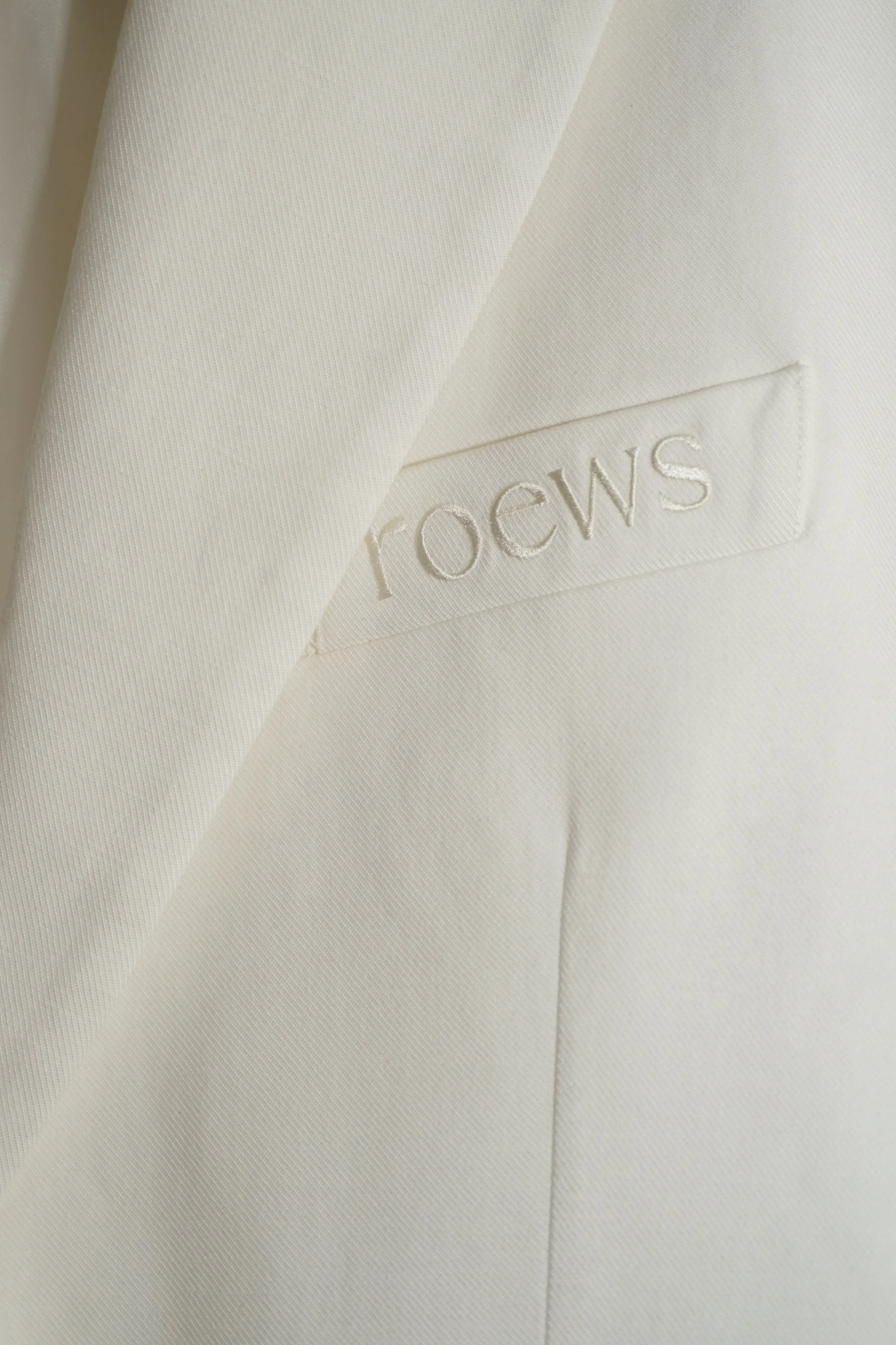 Close-up van een witte Rochas jurk met een label.