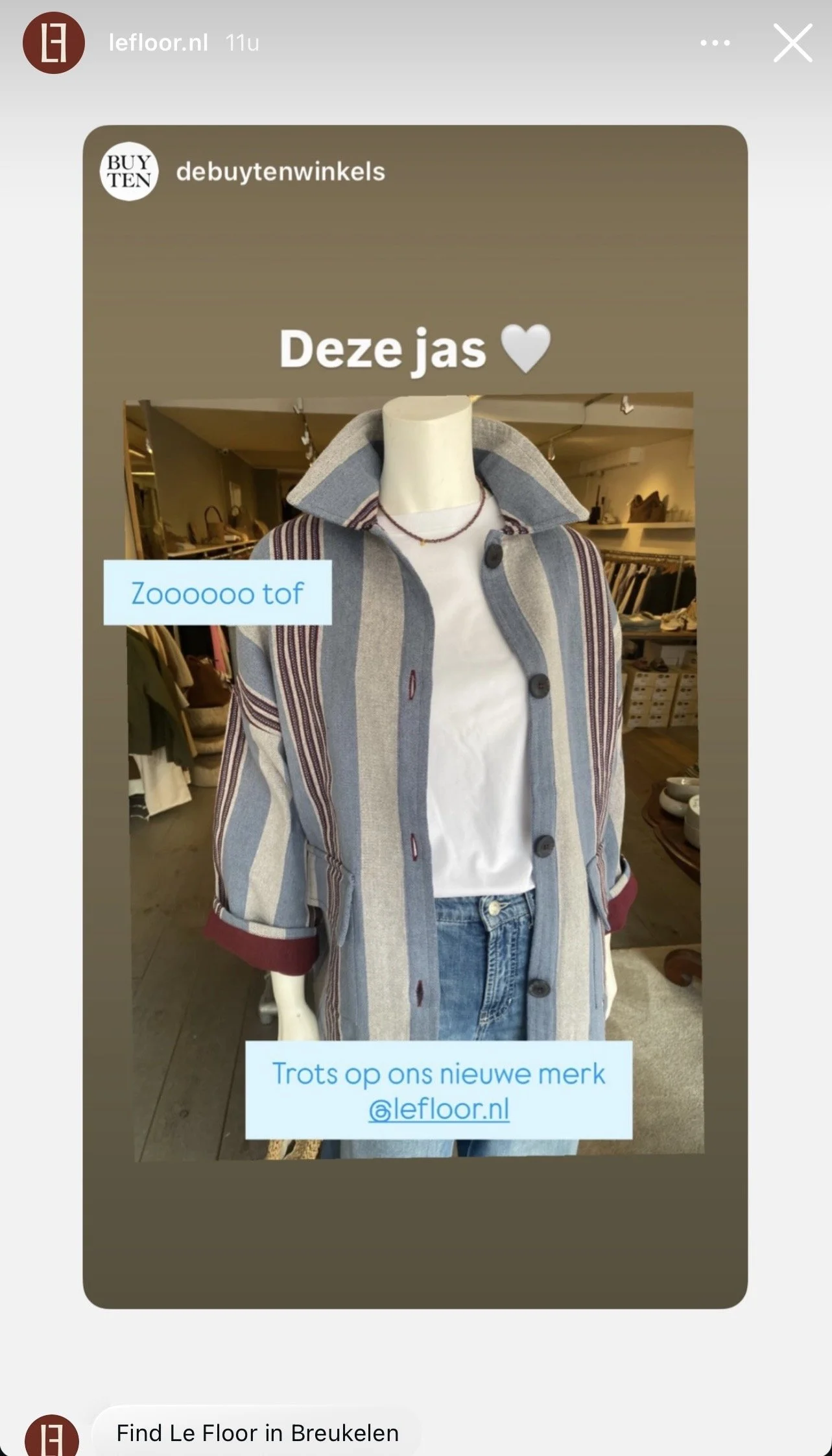 een mannequin met een gestreepte jas, een witte shirt en blauwe spijkerbroek, gepresenteerd in een winkelomgeving.