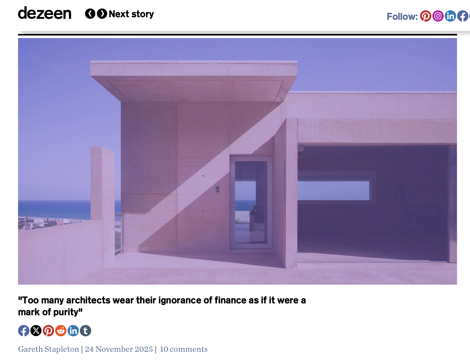 Modern concrete building with geometric shapes, large rectangular opening, and a glass door, overlooking a cityscape and ocean in the background.