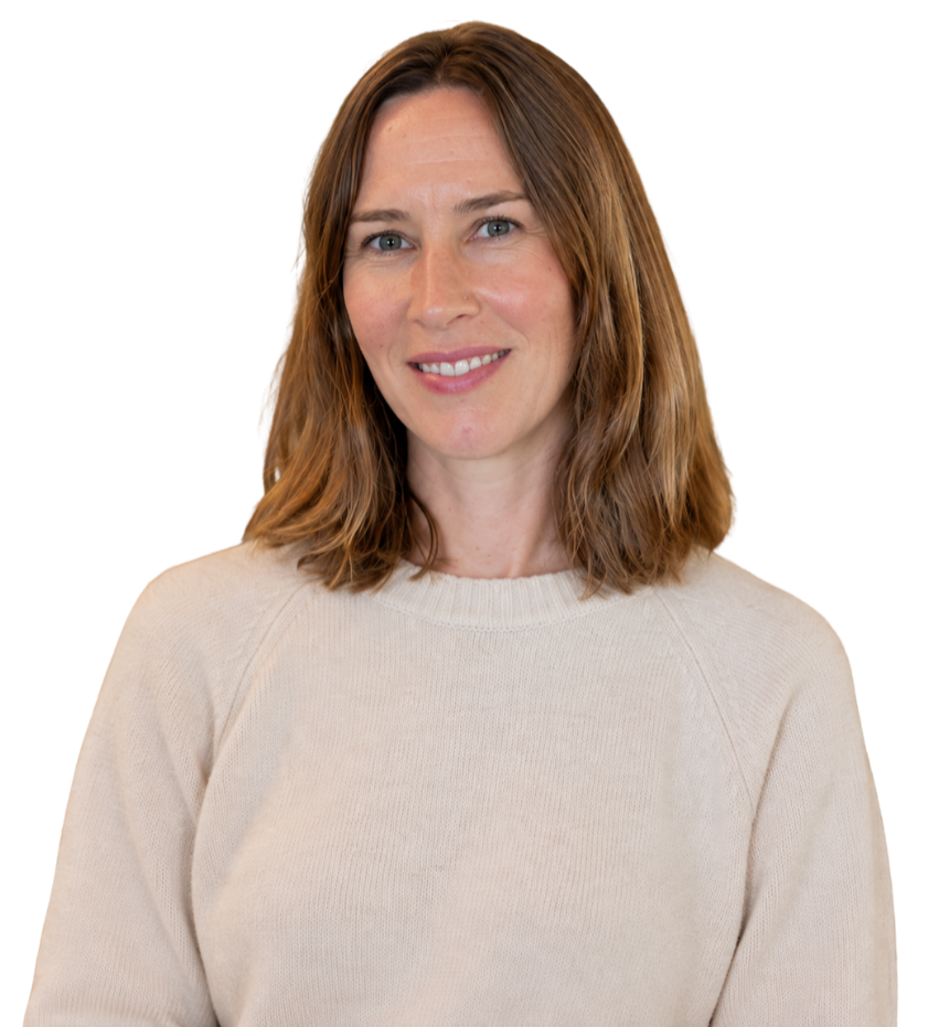 A woman with shoulder-length brown hair and fair skin, smiling and wearing a cream-colored sweater, against a plain background.