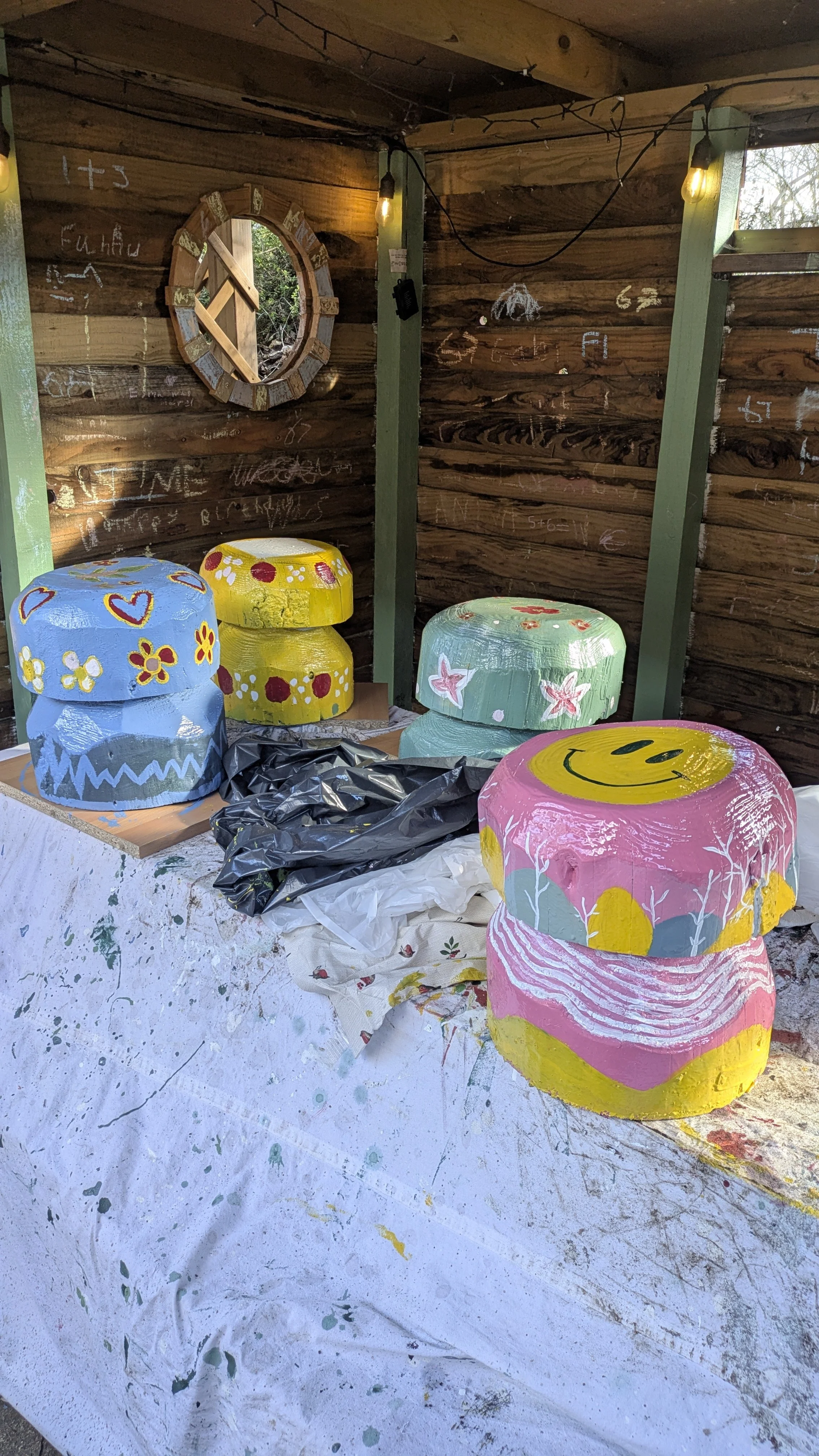 in the forefront is Mollys pink smiling mushroom and behind it is a blue and red flowered mushroom yellow dotty mushroom and green and red flowered mushroom.