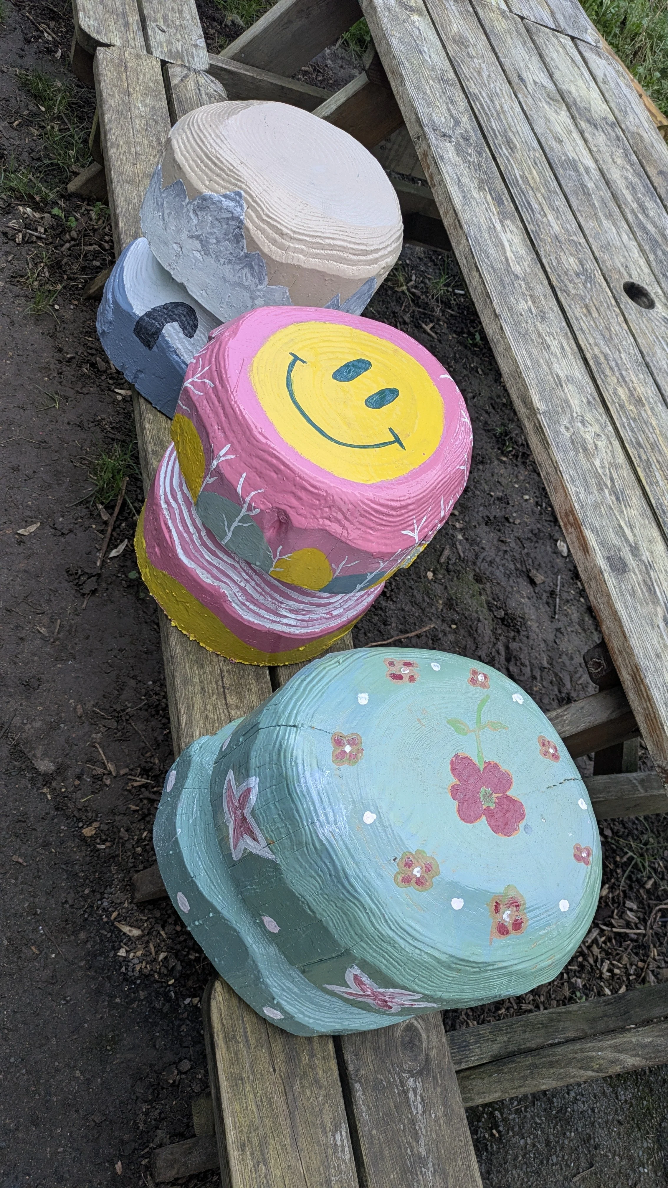 Three of the painted mushrooms on a bench