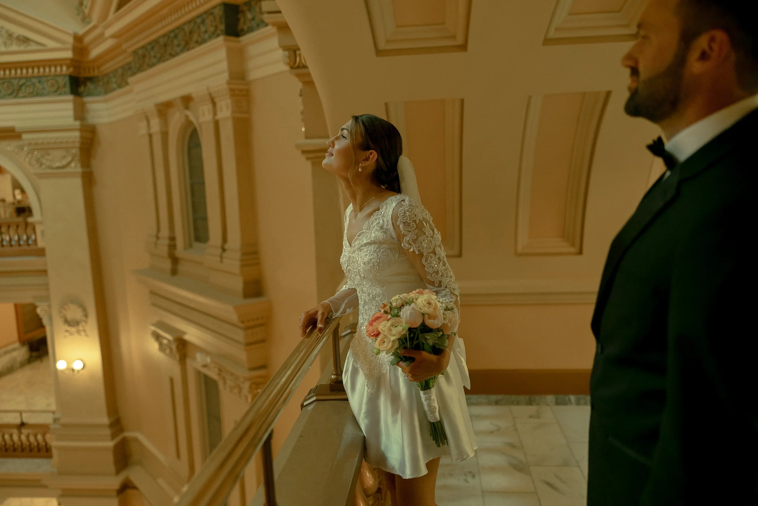 Bride looking up at the Capitol's marble hallway in Topeka, Kansas.